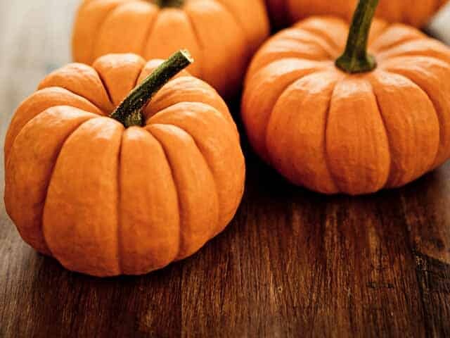 Little pumpkins on brown wood