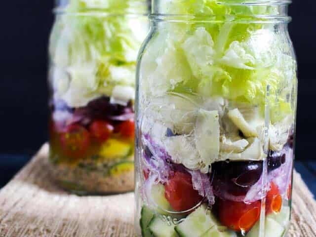 Two salads in mason jars on table