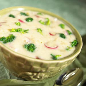 green curry soup with broccoli and vegetables in a textured green bowl