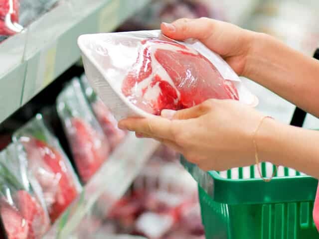 Lady shopping and holding packaged meat