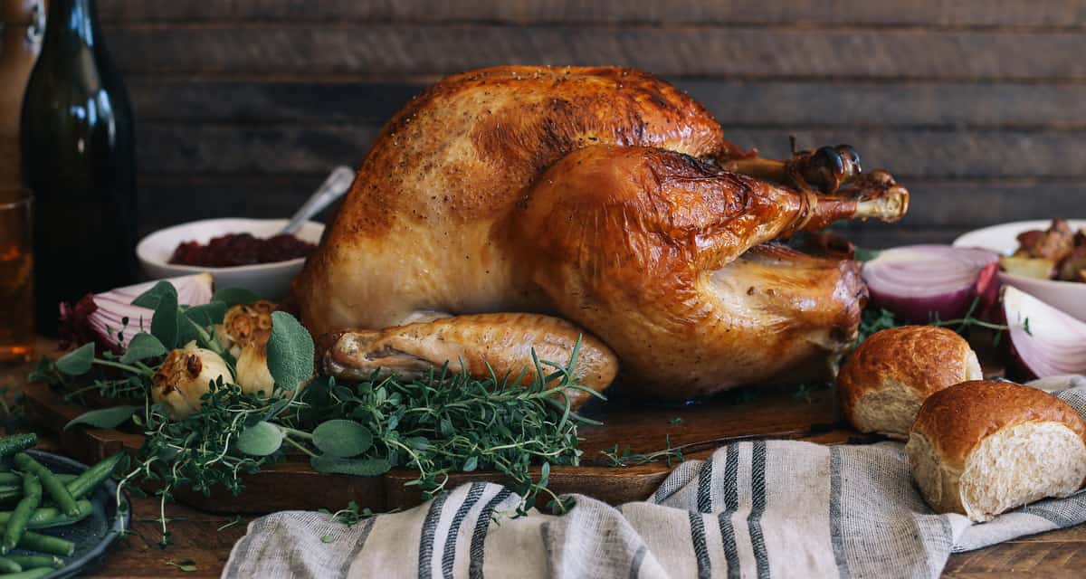 Roasted turkey on a platter with onion, rosemary and sage