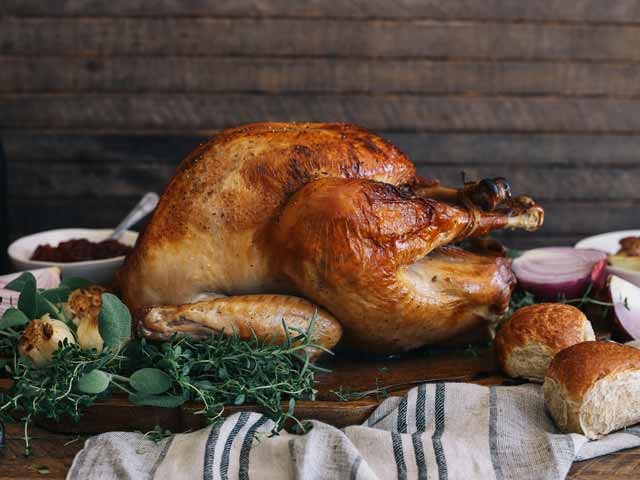 Roasted turkey on a platter with onion, rosemary and sage