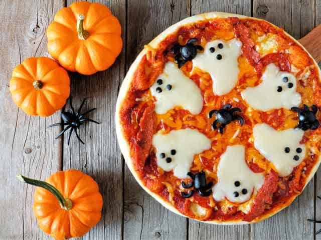 Pizza with ghost shapes on it.