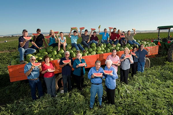 George Perry family gathered around a wagon filled with melons.