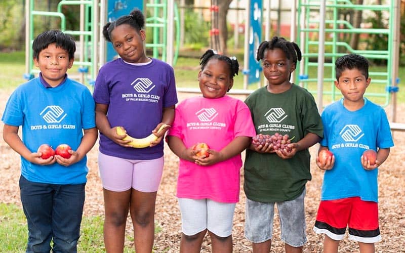 kids boys & girls club of palm beach holding apples