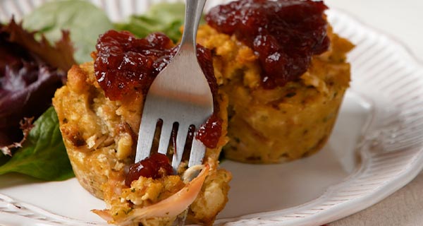 Stuffing muffins on a plate next to a salad