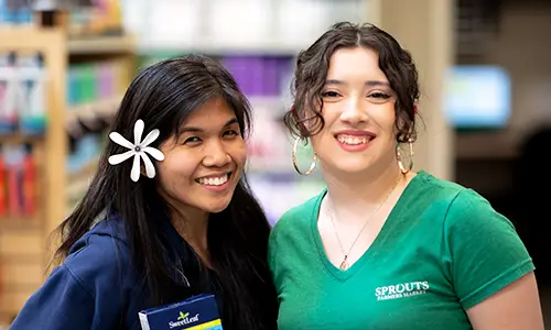 two store associates smiling